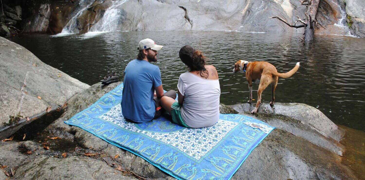 Man, woman and dog by river on Tarpestry